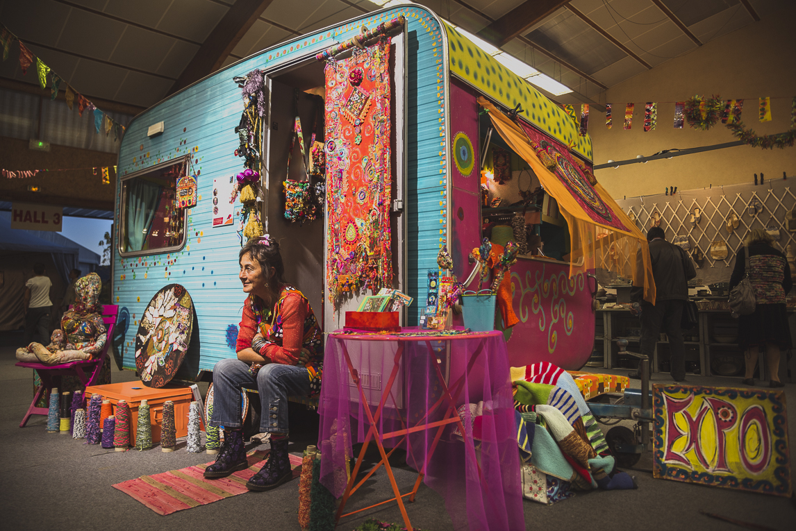 rozimages - photographie évènementielle - Salon des Arts et du Feu 2015 - caravane colorée et artiste assise devant sa porte - Martres-Tolosane, France