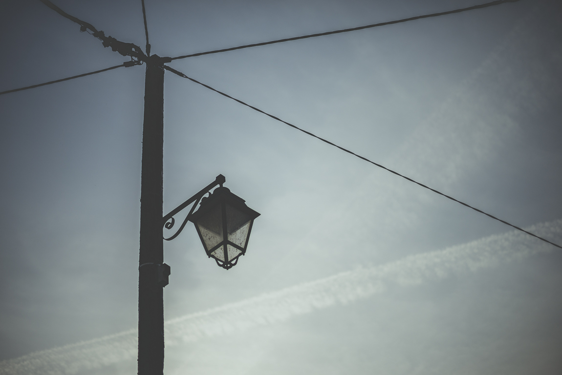 Reportage village Alan - lampadaire et cables électriques devant ciel bleu - Photographe voyage