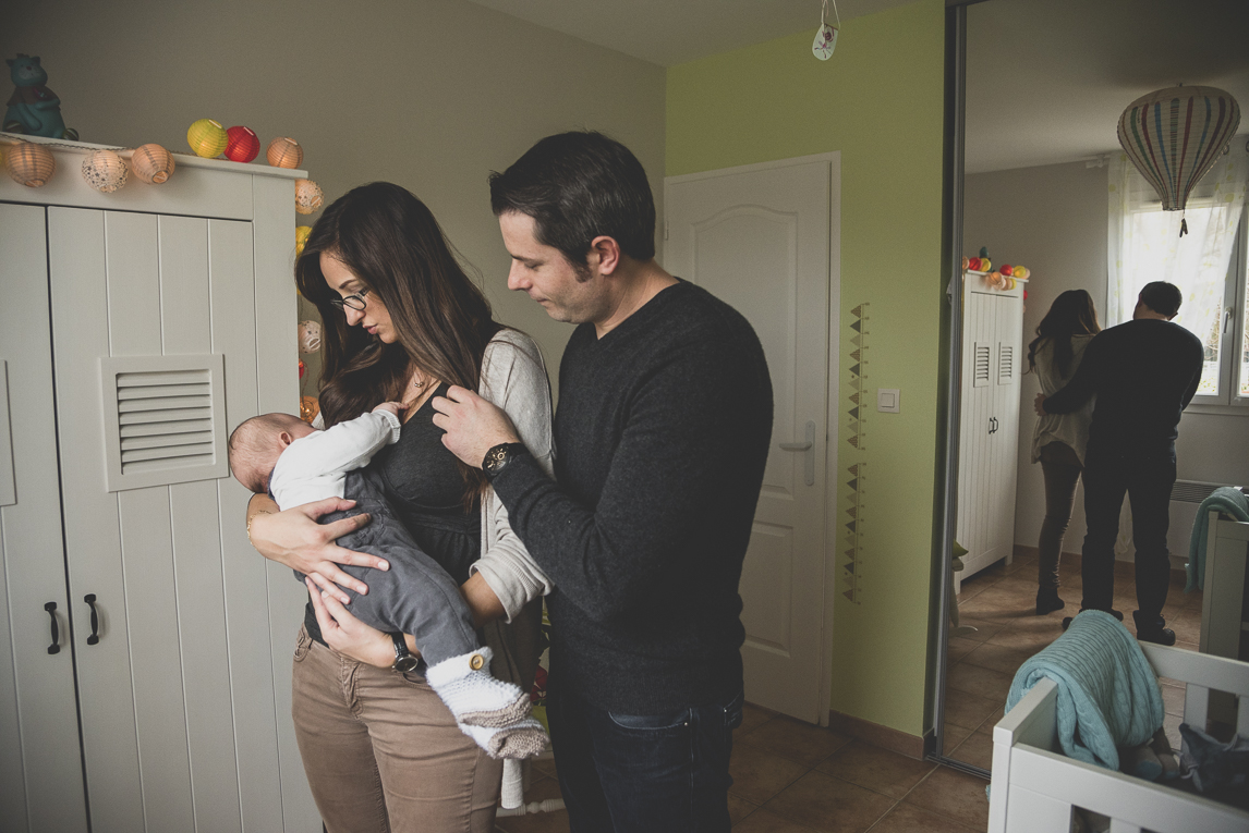 Séance bébé à domicile - papa maman avec leur bébé dans la chambre d'enfant - Photographe bébé