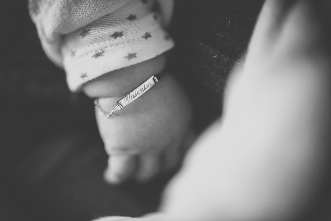 Baby photo session at home - close up on baby's hand and chain bracelet with first name - Baby Photographer