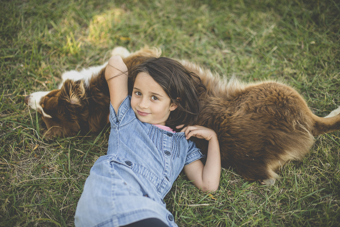 Family photo session Ariège - little girl lying on her dog - Family Photographer