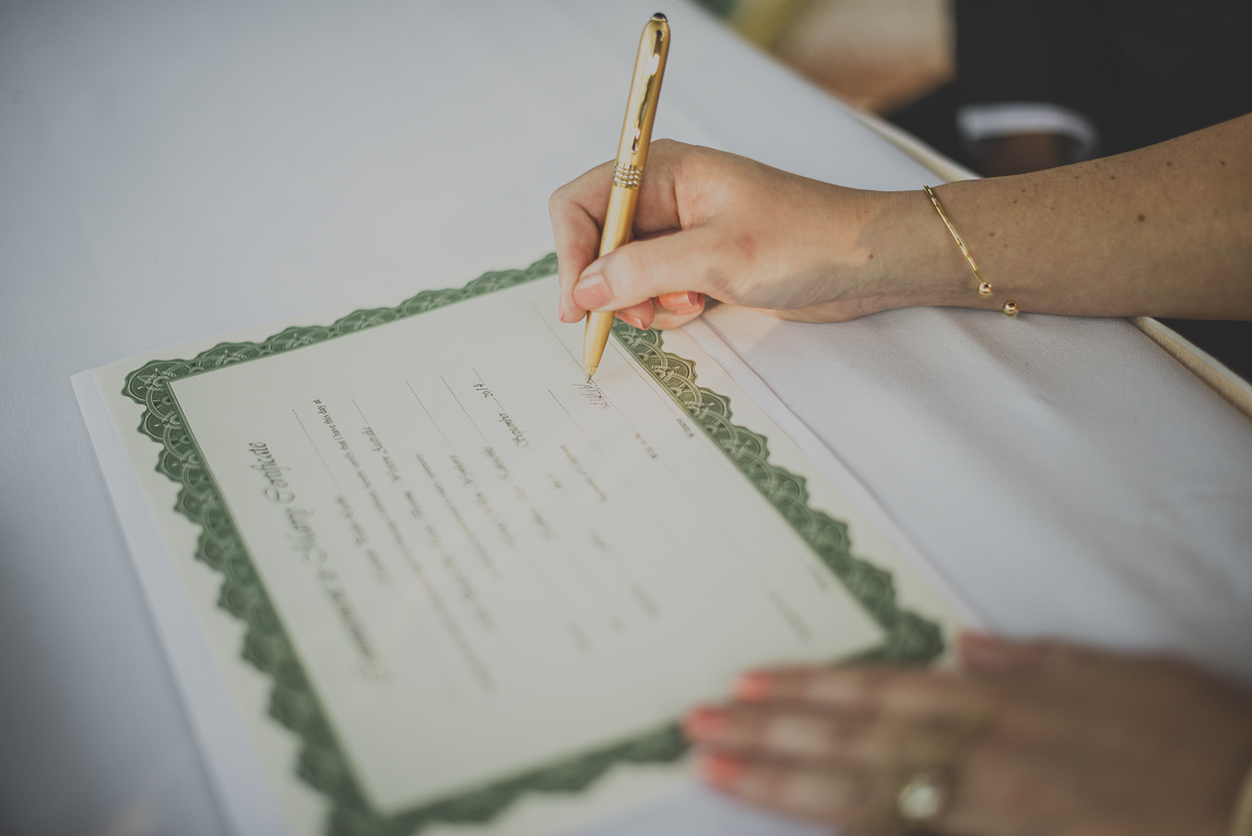 rozimages - photographie de mariage - certificat en train d'être signé par la mariée, gros plan sur certificat et mains - Broome, Australie