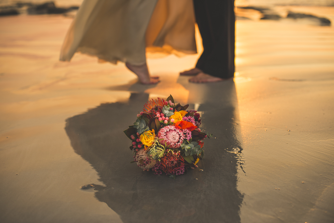 rozimages - wedding photography - bouquet on the sand, feet of bride and groom in background - Broome, Australia