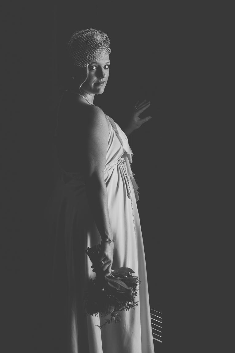 rozimages - wedding photography - bride standing in light in front of door, rest of picture is black - Broome, Australia