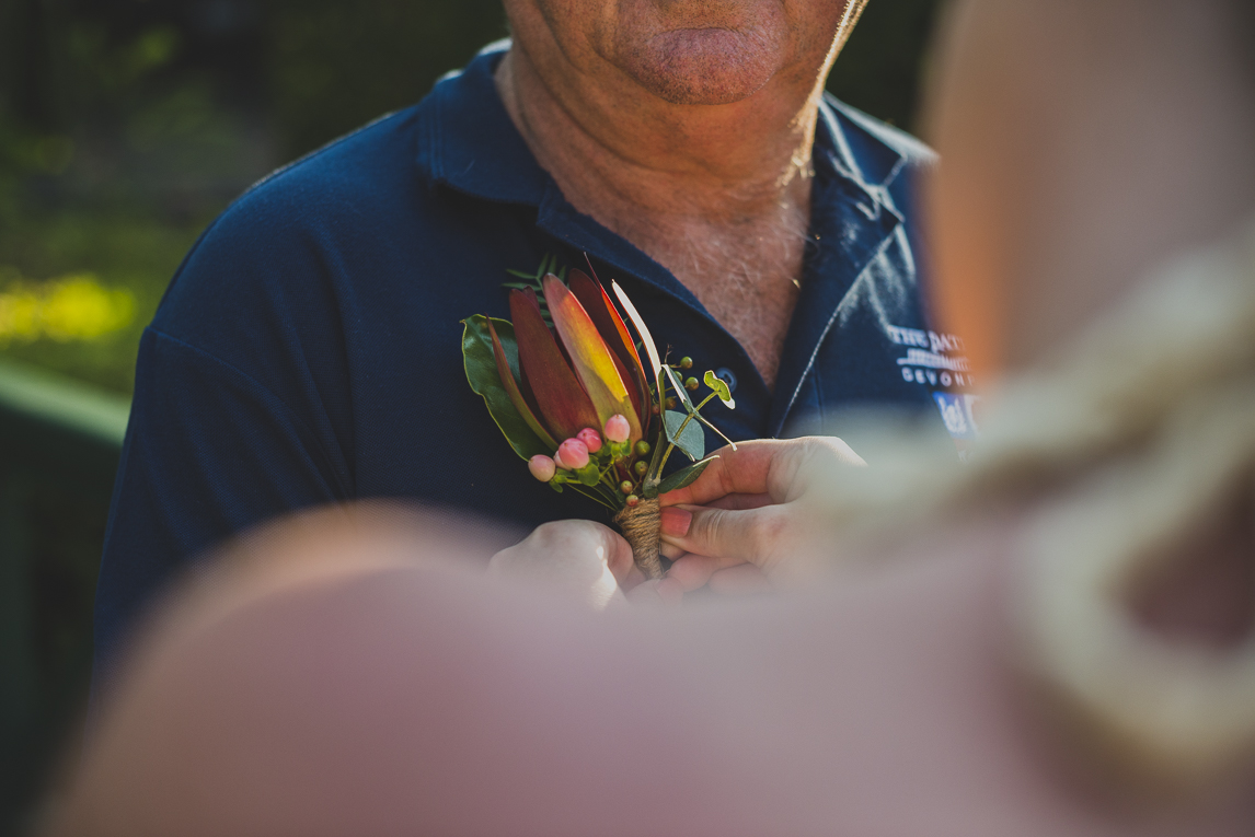 rozimages - photographie de mariage - gros plan sur la boutonnière en train d'être épinglée sur une chemise - Broome, Australie