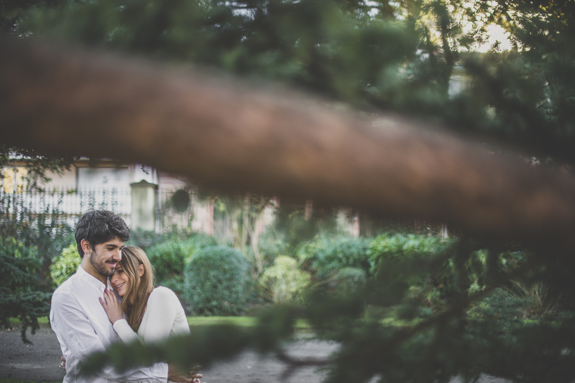 rozimages - photographie de couple - couple se faisant un calin derrière des branches d'arbre - Jardin des plantes, Toulouse, France