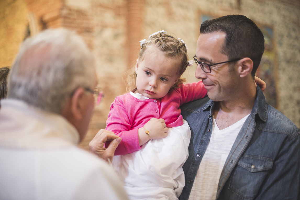 Baptême à Mondavezan - petite fille dans les bras de son papa - Photographe de famille