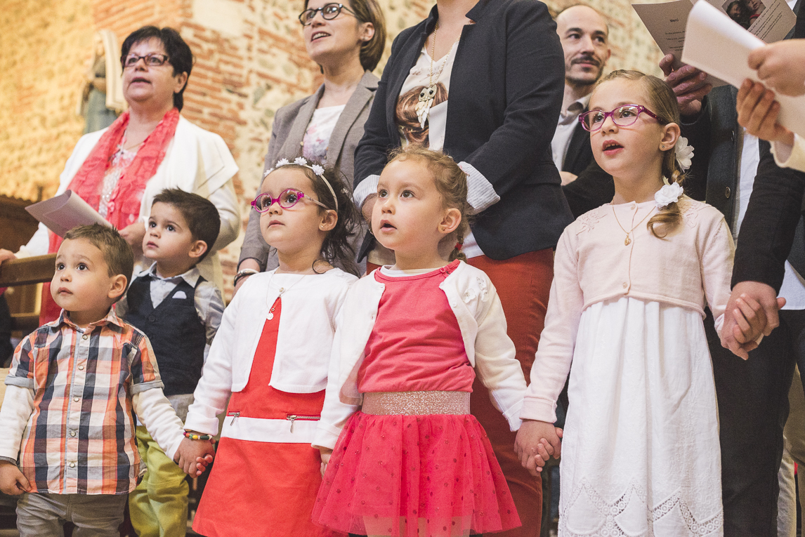 Baptême à Mondavezan - enfants chantant et se tenant la main - Photographe de famille