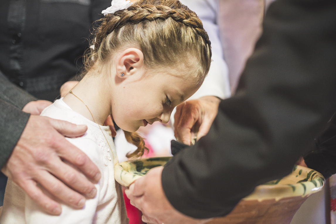 Baptême à Mondavezan - Eau versée sur la tête d'une petite fille - Photographe de famille