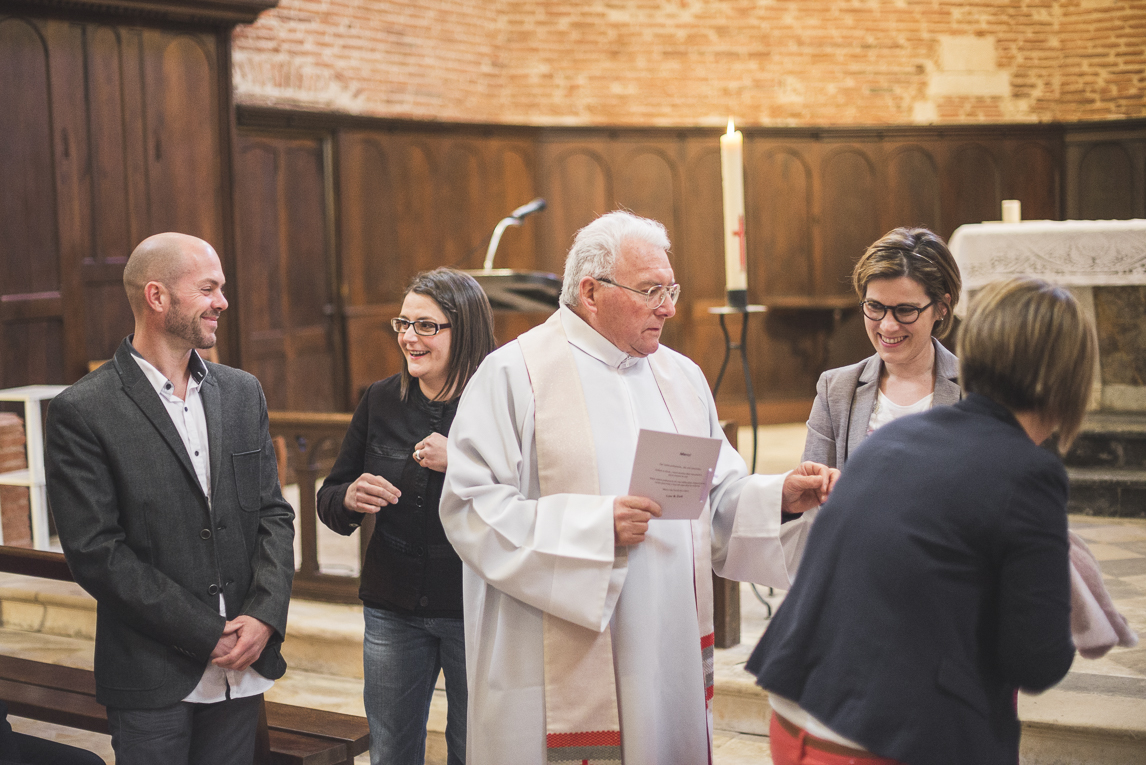 Baptême à Mondavezan - prêtre et famille dans une église - Photographe de famille