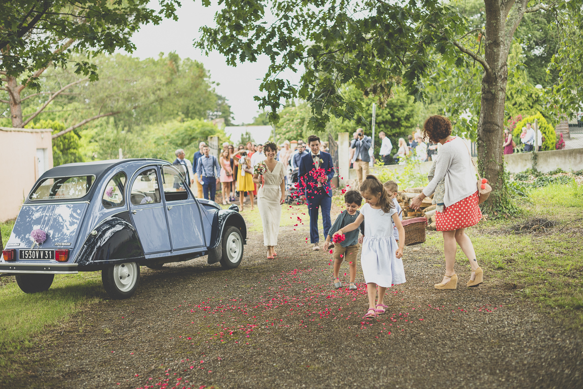 Reportage mariage Toulouse - enfants jettent pétales de roses sur chemin - Photographe mariage