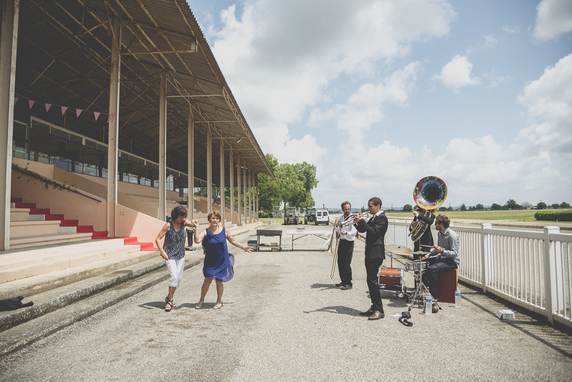 Reportage mariage Toulouse - deux femmes dancent près d'un orchestre - Photographe mariage