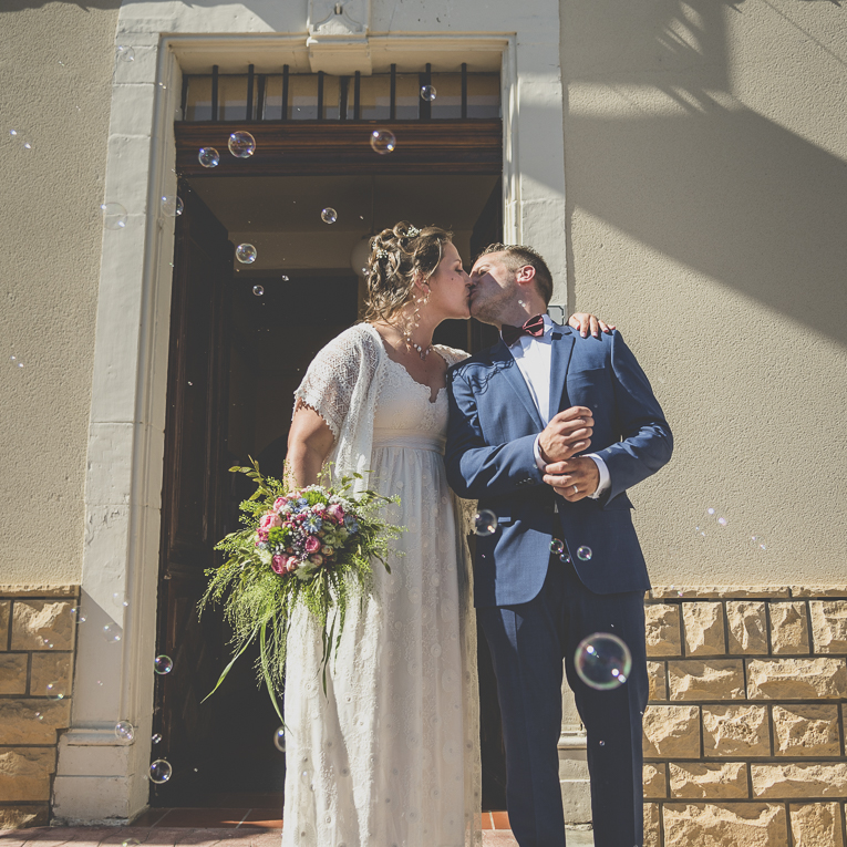 Reportage mariage Sud-Toulousain - mariés d'embrassant à la sortie de la mairie - Photographe mariage