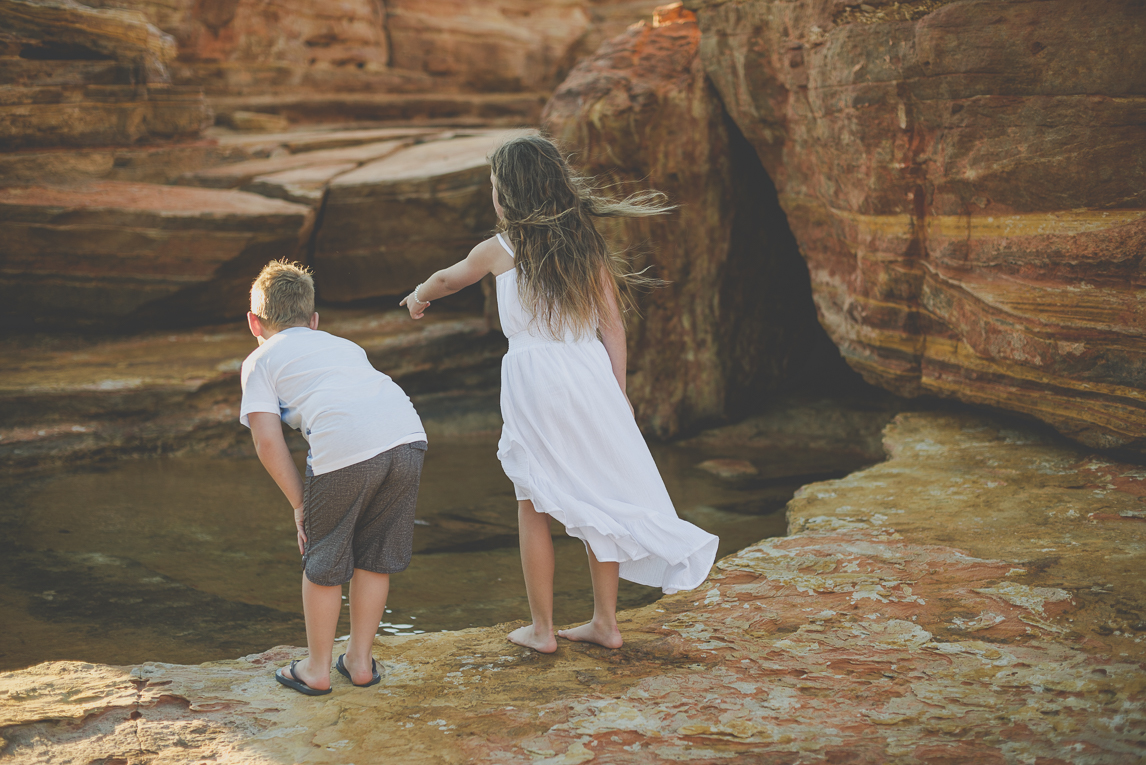 Family photo session - two children look into a pond among rocks - Family Photographer
