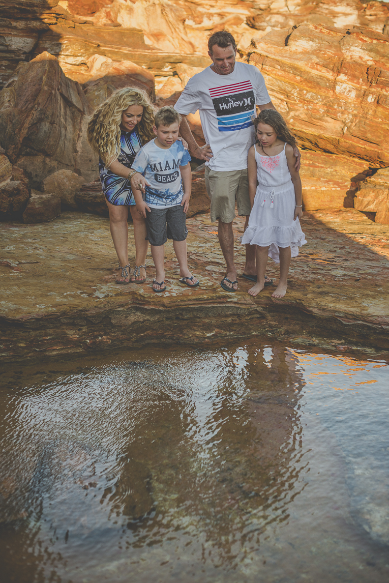 Séance photo famille - famille regardant dans un bassin parmis les rochers - Photographe famille