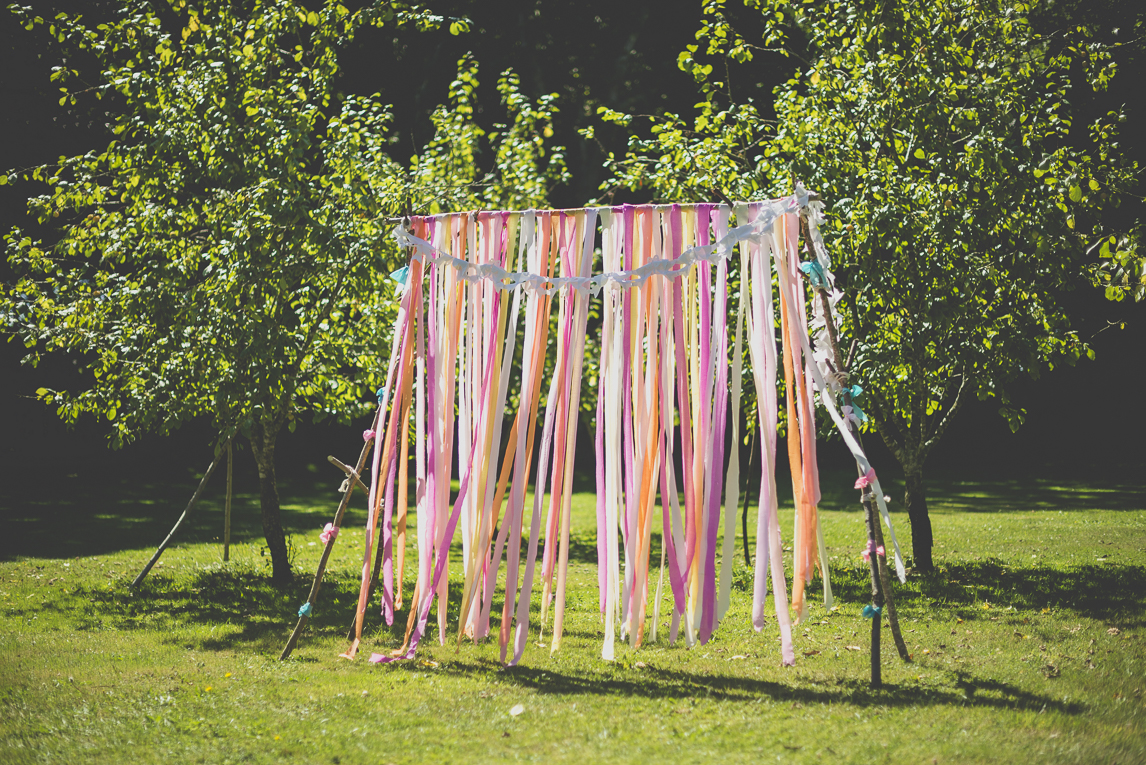 Reportage mariage Bretagne - arche de mariage avec des franges de papier coloré - Photographe mariage