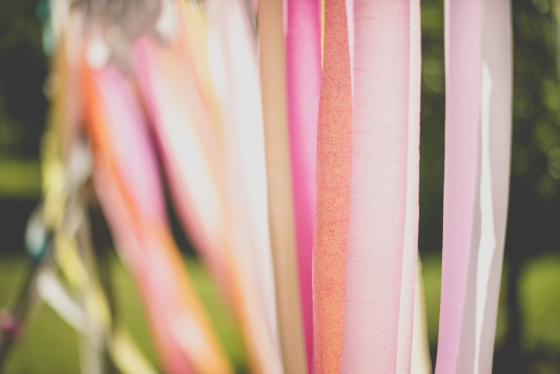 Wedding Photography Brittany - strings of coloured paper from wedding arch - Wedding Photographer