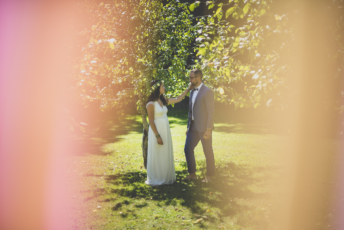 Reportage mariage Bretagne - mariés debout près des arbres fruitiers - Photographe mariage