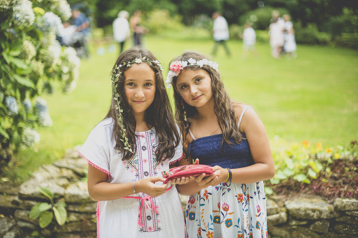 Reportage mariage Bretagne - deux petites filles tenant coussinet rose avec les alliances - Photographe mariage