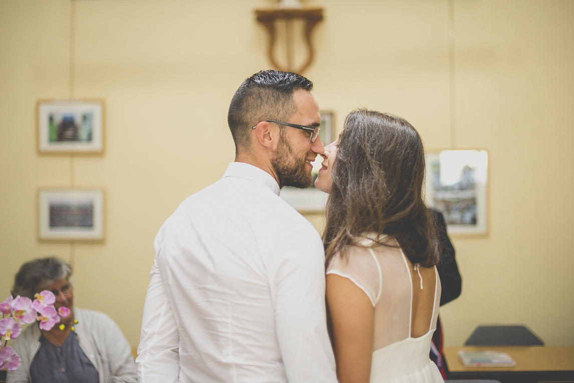 Reportage mariage Bretagne - baiser des mariés à la mairie - Photographe mariage