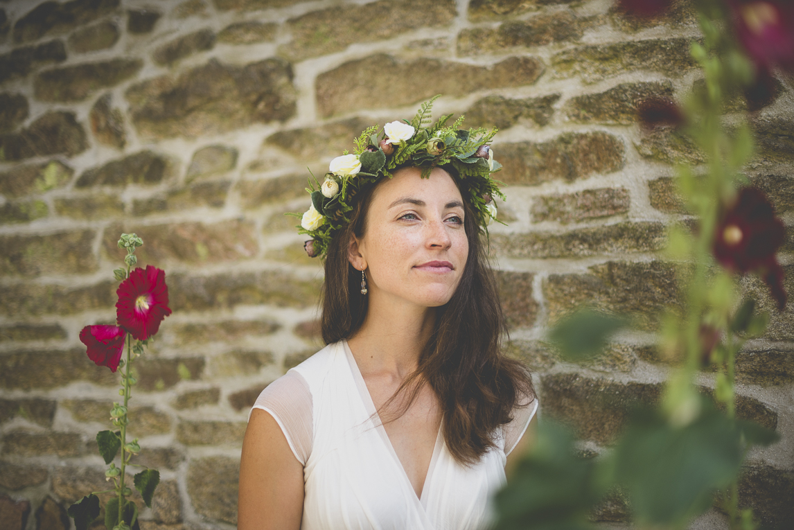 Reportage mariage Bretagne - portrait de la mariée parmis les roses trémières - Photographe mariage