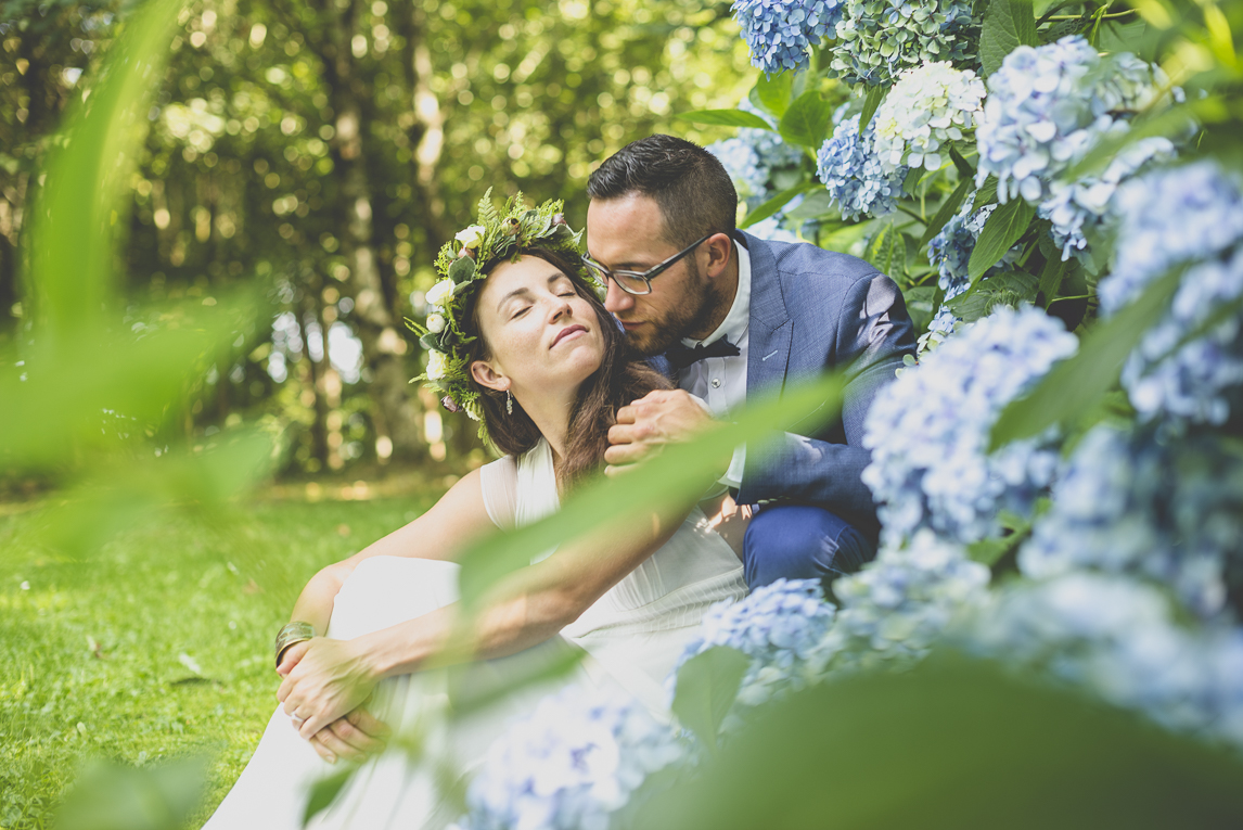 Reportage mariage Bretagne - mariés parmis les hortensias bleus - Photographe mariage