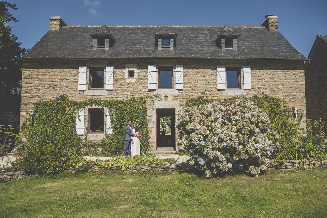 Reportage mariage Bretagne - mariés devant maison de pierre - Photographe mariage