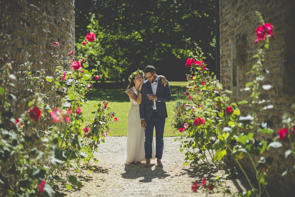 Reportage mariage Bretagne - mariés au milieu des roses trémières - Photographe mariage