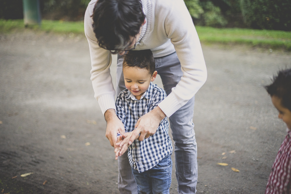 Séance photo famille - papa aide son petit garçon à se frotter les mains - Photographe famille