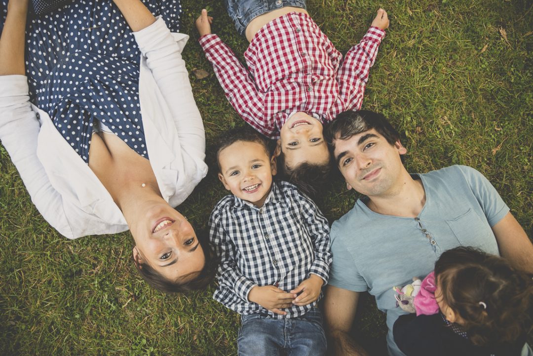 Séance photo famille - parents et deux enfants allongés dans l'herbe - Photographe famille