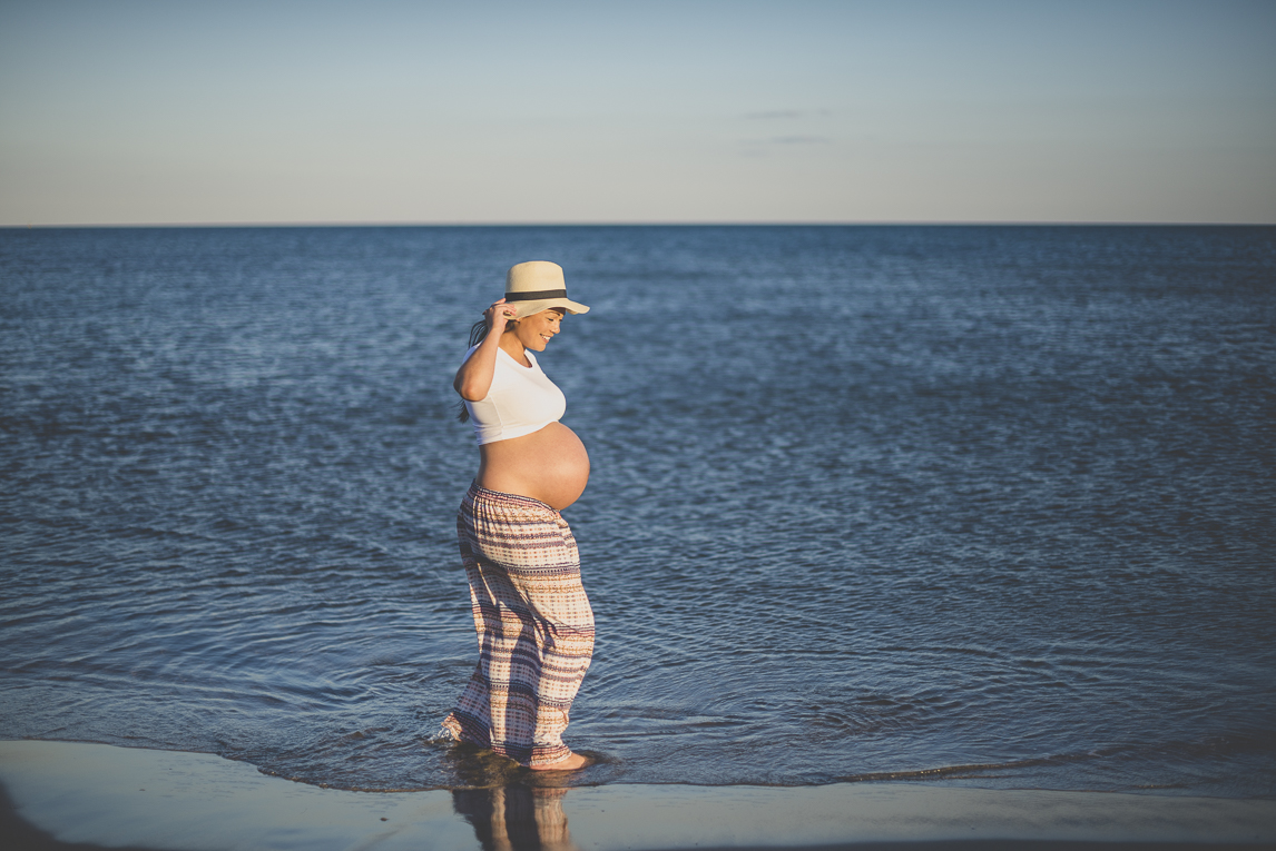 Séance photo grossesse à la plage - femme enceinte de profil devant le bleu de la mer - Photographe grossesse