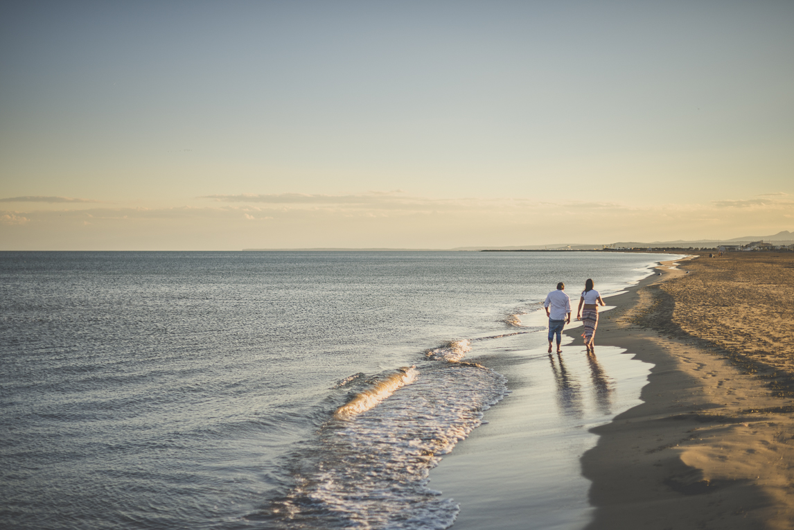 Séance photo grossesse à la plage - couple marche le long de la mer - Photographe grossesse
