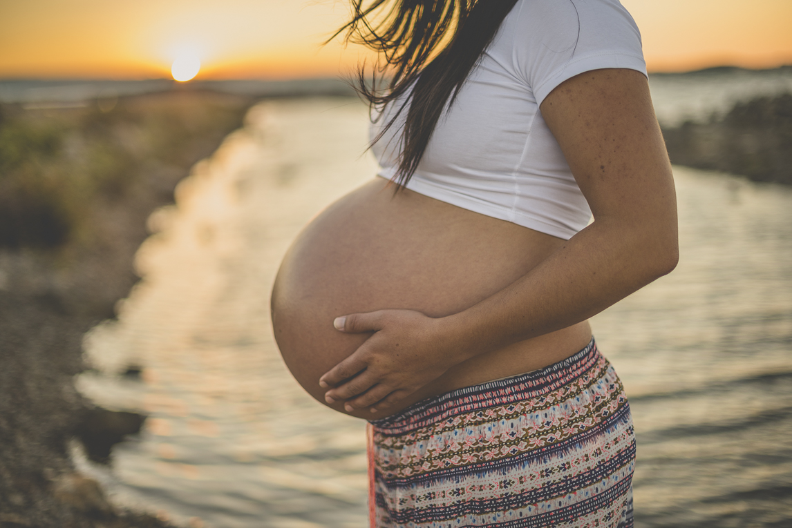 Séance photo grossesse à la plage - femme enceinte de profil devant la mer - Photographe grossesse