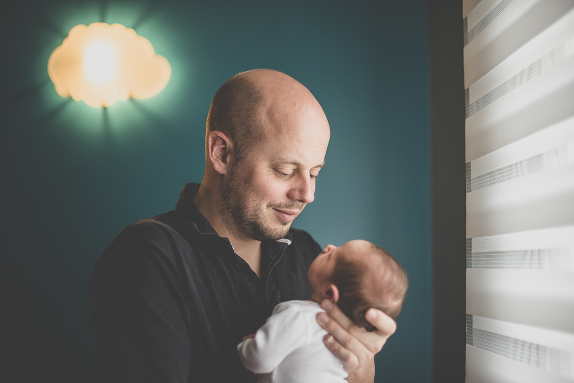 Newborn photo-shoot - dad holds his baby in his arms - Newborn Photographer