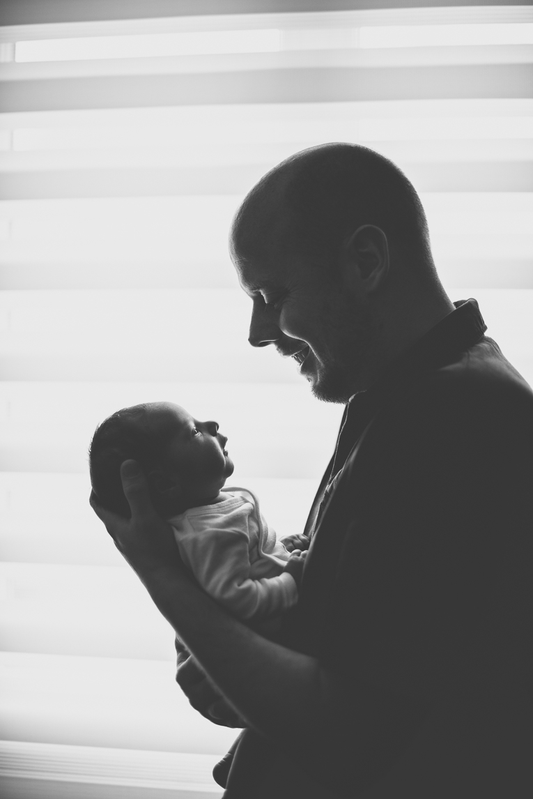 Newborn photo-shoot - silhouettes of dad and baby who look at each other - Newborn Photographer