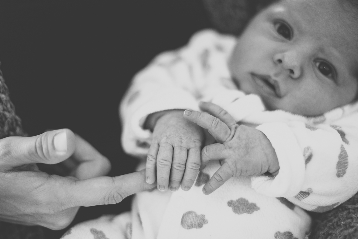 Séance photo nouveau-né Muret - bébé tient le doigt de maman - Photographe naissance