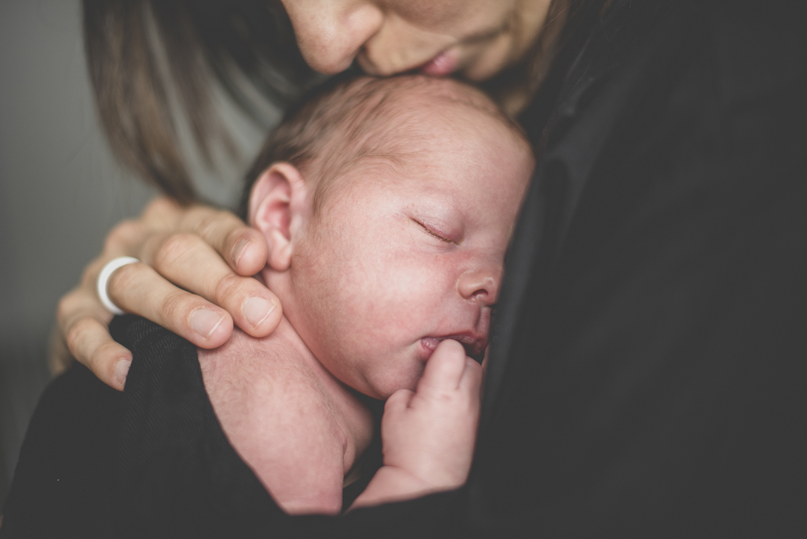 Newborn photo-shoot - newborn sleeping in the arms of his mum - Newborn Photographer