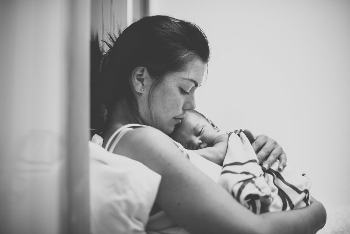 Séance photo naissance à domicile Occitanie - maman tient son nouveau-né dans ses bras - Photographe naissance