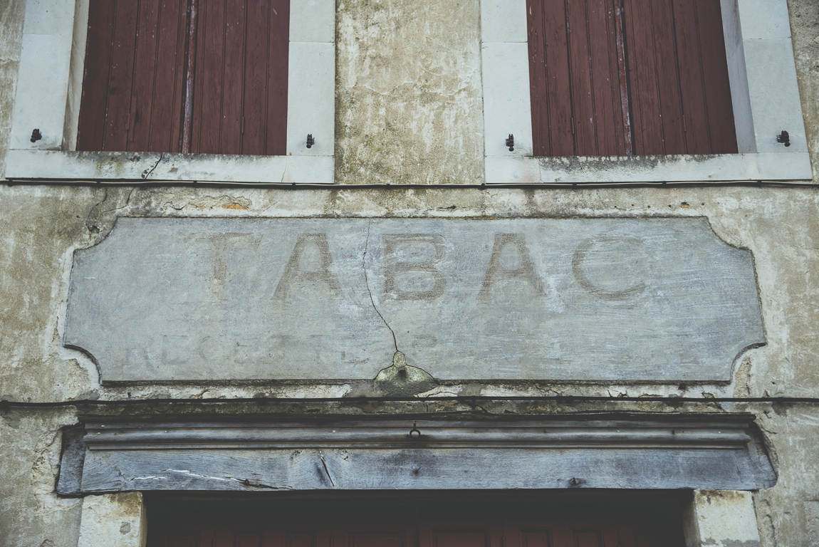 Reportage village Alan - ancien panneau tabac - Photographe voyage