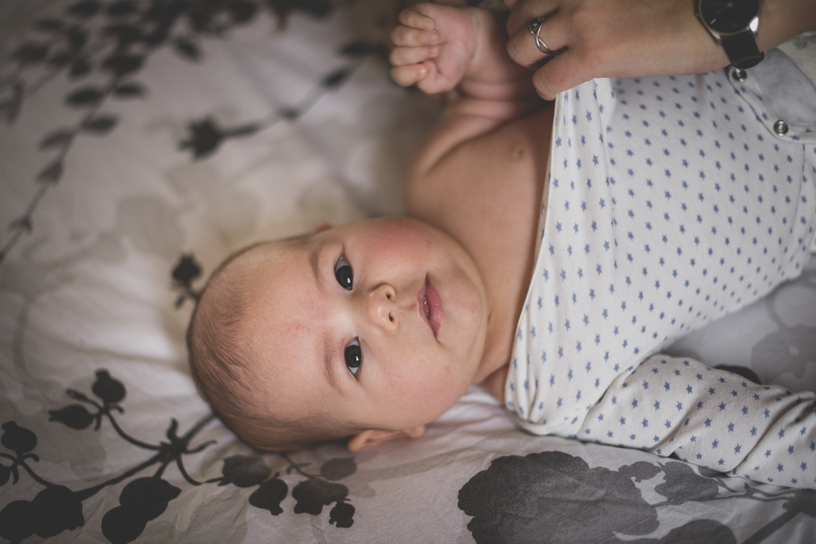 Séance bébé à domicile - bébé qui se fait changer - Photographe bébé