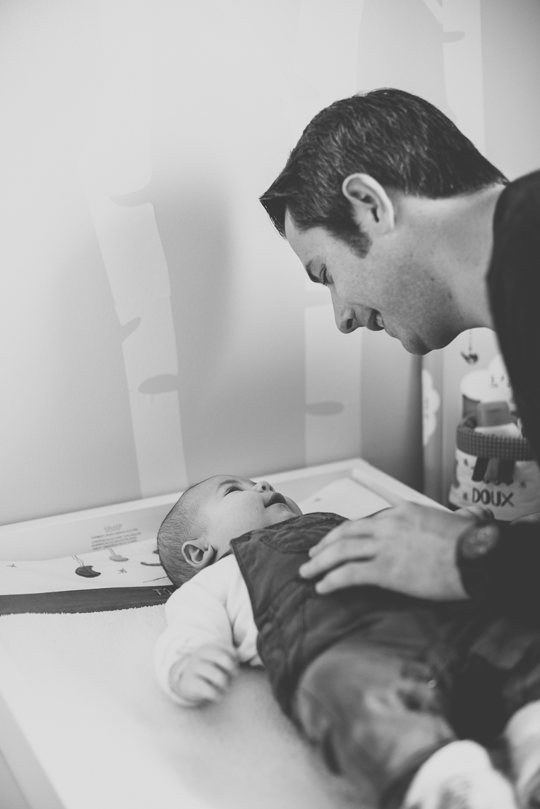 Séance bébé à domicile - bébé sourit à son papa - Photographe bébé