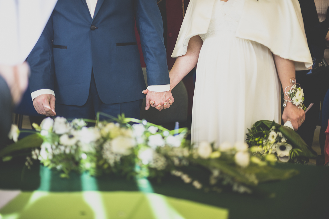 Reportage mariage hiver - mariés se tiennent la main pendant cérémonie civile - Photographe mariage