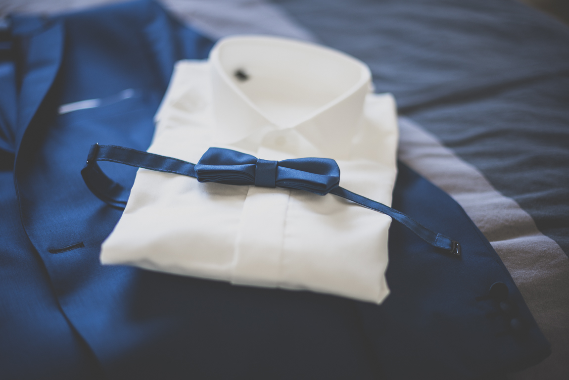 Reportage mariage hiver - noeud papillon chemise et veste du marié posés sur lit - Photographe mariage