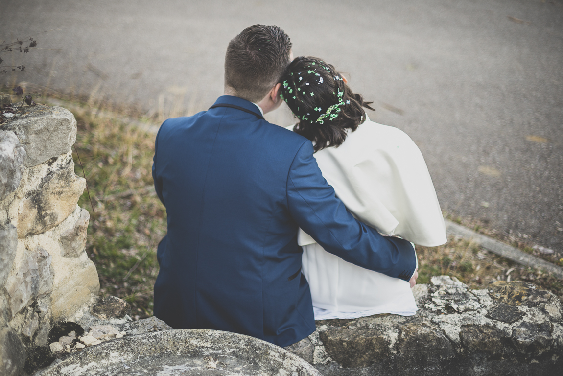 Reportage mariage hiver - mariés assis sur muret l'un contre l'autre - Photographe mariage