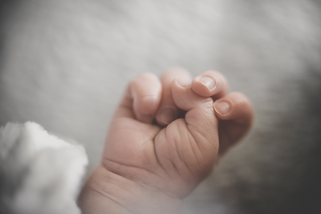 Séance nouveau-né à domicile Saint-Gaudens - gros plan sur poing de bébé - Photographe nouveau-né
