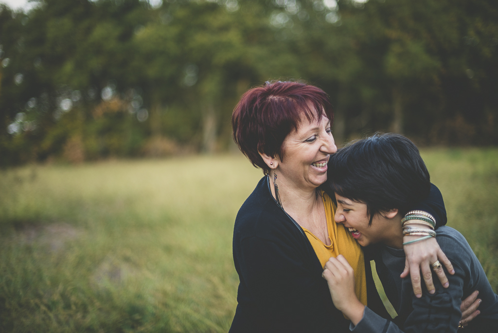 Séance famille en extérieur - garçon rigole dans les bras de sa maman - Photographe famille