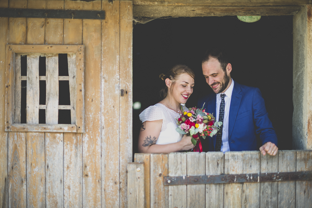 Reportage mariage Haute-Garonne - mariés derrière porte d'étable - Photographe mariage