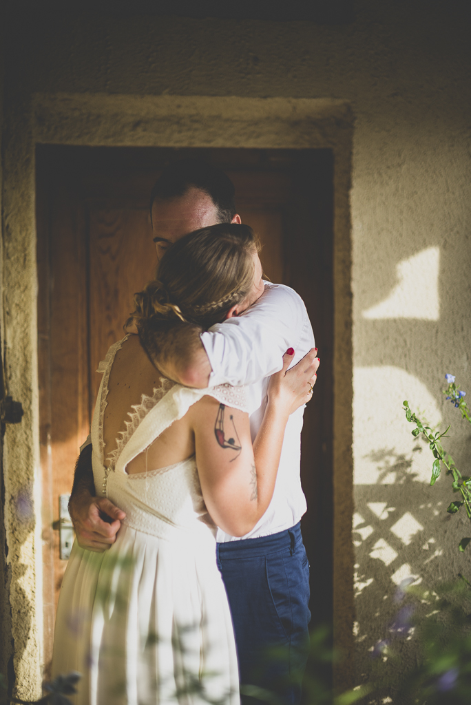 Reportage mariage Haute-Garonne - calin des mariés sous porche - Photographe mariage