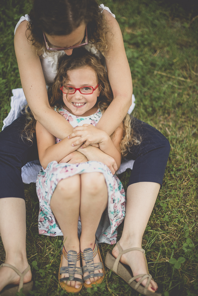 Séance famille Haute-Garonne - calin mère et fille dans l'herbe - Photographe famille Toulouse