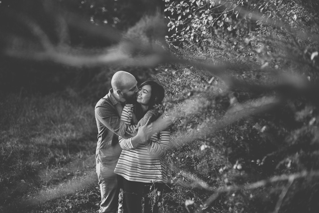 Séance photo en amoureux en exterieur - couple entrelacé derriere branches - Photographe couple Toulouse